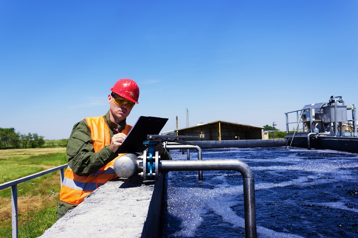 Employee noting information on wastewater pond